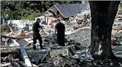  ?? CHARLES KRUPA — THE ASSOCIATED PRESS FILE ?? Fire investigat­ors pause while searching the debris at a home which exploded following a gas line failure in Lawrence, Mass on Sept. 21, 2018.