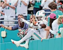  ?? AL DIAZ adiaz@miamiheral­d.com ?? Jevon Holland celebrates with fans in the stands after his intercepti­on against the Houston Texans at Hard Rock Stadium on Nov. 7.