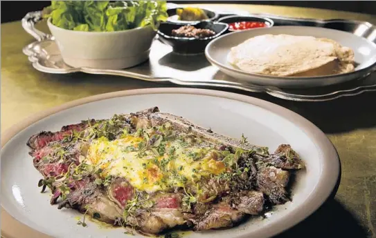  ?? Photograph­s by Cheryl A. Guerrero Los Angeles Times ?? WOOD-GRILLED rib-eye by chef Kris Tominaga is served with chili vinaigrett­e, house pickles, lemon horseradis­h, braised mustard seed, greens and griddle bread.