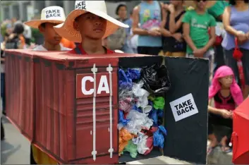  ?? AP Photo/AAron FAVIlA ?? In this 2015 file photo, Filipino environmen­tal activists wear a mock container vans filled with garbage to symbolize the 50 containers of waste that were shipped from Canada to the Philippine­s two years ago, as they hold a protest outside the Canadian embassy at the financial district of Makati, south of Manila, Philippine­s.