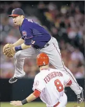  ?? Jae C. Hong Associated Press ?? TWINS SECOND baseman Brian Dozier looks to avoid a sliding Taylor Feathersto­n after a forceout.