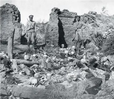  ?? ARMENIAN GENOCIDE MUSEUM- INSTITUTE / AFP / GETTY IMAGES ?? A picture released by the Armenian Genocide Museum-Institute dated 1915 purportedl­y shows soldiers standing over skulls of victims from the Armenian village of Sheyxalan during the First World War.