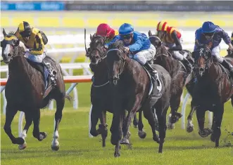  ??  ?? Jockey Glyn Schofield (centre) rides Kementari to win the 2018 Randwick Guineas.