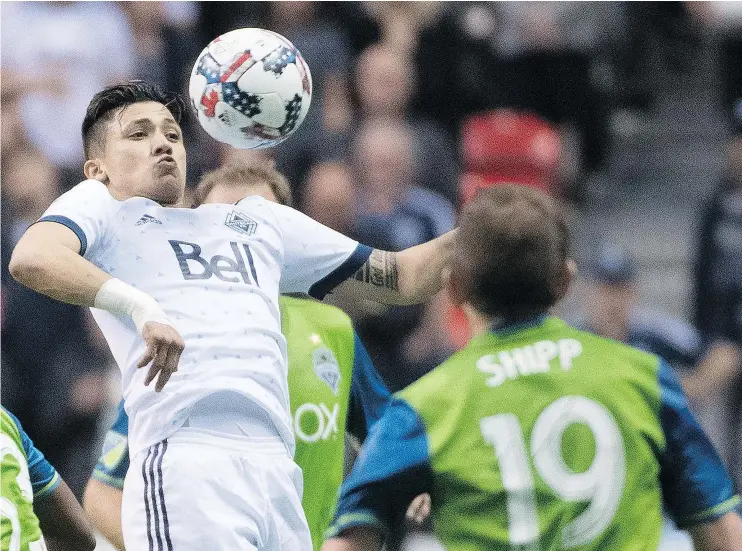  ?? THE CANADIAN PRESS ?? Vancouver’s Fredy Montero fights for control of the ball with Seattle’s Harry Shipp in the first half of Friday’s game at B.C. Place. Vancouver won 2-1.