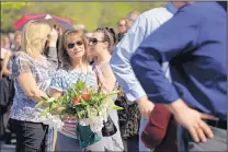  ?? JAE C. HONG/THE ASSOCIATED PRESS ?? Teresa Spraggs holds flowers while waiting in line Thursday to board a bus to take her to the Ronald Reagan Presidenti­al Library for the public viewing of ex-first lady Nancy Reagan.