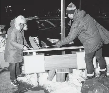  ??  ?? P.J. Gach, left, and Sonia Izak measure a table they found discarded Feb. 10 on the Upper East Side of Manhattan. The pandemic has spawned a huge wave of items tossed out on New York City’s streets. JUTHARAT PINYODOONY­ACHET/THE NEW YORK TIMES