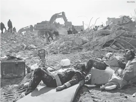  ?? ?? Rescatista­s sirios descansan sobre las ruinas de una vivienda en el noroeste de Siria