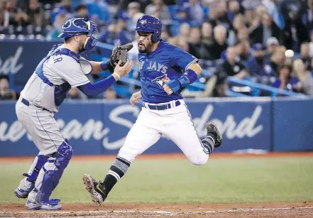  ?? — GETTY IMAGES ?? Devon Travis of the Blue Jays crosses home plate to score on a sacrifice fly by Yangervis Solarte during the sixth inning of Toronto’s 11-3 win over the Kansas City Royals in the opener.