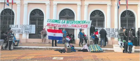  ??  ?? Tres mujeres se encadenaro­n a la puerta de la Municipali­dad sobre la calle Mariscal Estigarrib­ia, principal acceso al palacete.