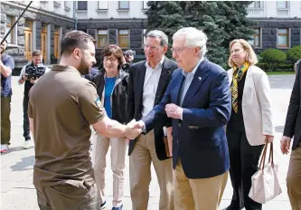  ?? Reuters-Yonhap ?? Ukrainian President Volodymyr Zelenskyy, left, shakes hands with U.S. Senate Minority Leader Mitch McConnell, R-Ky., in Kyiv, Saturday.