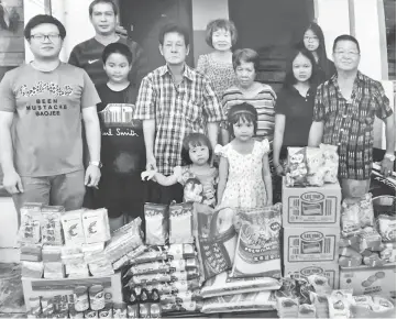  ??  ?? Lim (third left) and his entourage in a photo with recipients at KMC Flats