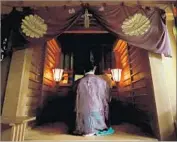  ?? Jiji Press By Jonathan Kaiman ?? A SHINTO priest holds a ceremony at the shrine on Japan’s Okinoshima island, a World Heritage site.