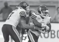  ?? PAUL CHIASSON/THE CANADIAN PRESS ?? Argos quarterbac­k Trevor Harris hands off to running back Henry Josey during pre-season play in Montreal on Thursday night.