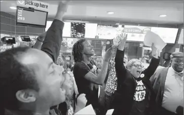 ?? Barbara Davidson Los Angeles Times ?? WORKERS hold a protest at a McDonald’s restaurant in L.A. to draw attention to the fact that wages will be boosted only at company-owned outlets. Rallies for a minimum wage boost are planned in 200 cities April 15.