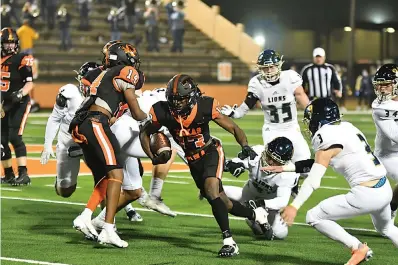  ?? Photo by Kevin Sutton ?? Texas High running back Daquarreon Witcher runs the ball with the help of a block from teammate Tre Roberts (14) during the Class 5A bi-district football game against Montgomery Lake Creek Friday at Tiger Stadium in Grim Park. Witcher scored twice in the second half to help the Tigers win, 37-7.