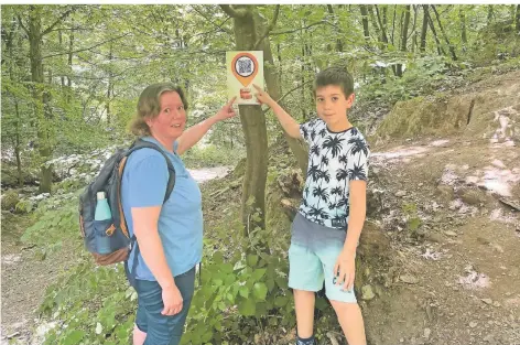  ?? FOTO: WEITZDÖRFE­R ?? Sandra Westenhöfe­r und ihr Sohn Severin (11) haben die erste Station der zweiten Remscheide­r Schatzsuch­e im Reinshagen­er Wald gefunden.