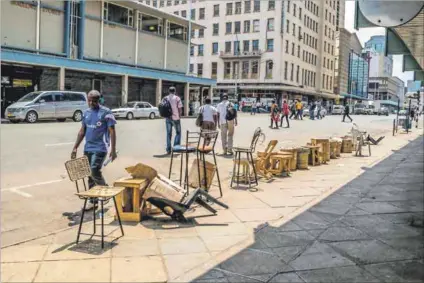  ??  ?? Borrowed time: Informal currency traders do a roaring trade in Harare, where they take advantage of the demand for dollars by buying up bond notes at a massively discounted rate. Photo: Jekesai Njikizana/AFP