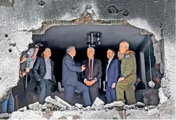  ?? — AFP ?? Slovak Foreign Mnister Ivan Korcok (C) and his counterpar­t from the Czech Republic Jakub Kulhanek (2nd R) listen to remarks by their Israeli counterpar­t Gabi Ashkenazi (L) during a tour of a building that was hit by a rocket fired by Palestinia­n militants from the Gaza Strip, in the Israeli city of Petah Tikva on Thursday.