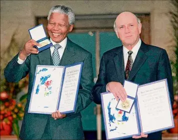 ?? Jon Eeg / Associated Press ?? South African Deputy President F.W. de Klerk, right, and South African President Nelson Mandela pose with their Nobel Peace Prize Gold Medal and Diploma, in Oslo, Dec. 10, 1993. F.W. de Klerk, who oversaw the end of the country’s white minority rule, has died.