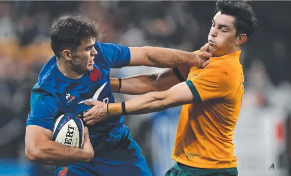  ?? Picture: AFP ?? France winger Damian Penaud palms off Wallabies fullback Jock Campbell on his way to scoring at the Stade de France in Paris.