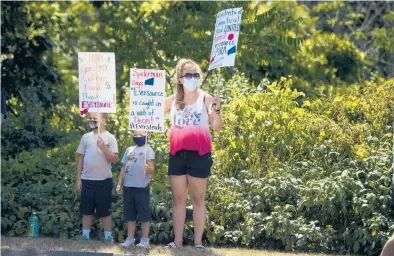  ?? KASSI JACKSON/HARTFORD COURANT ?? Damion Toran, 7, and his brother Liam Toran, 5, hold signs as they protest with their mom, Courtney Toran, of Naugatuck, outside of Eversource’s Berlin headquarte­rs in July.
Bills to get a userfriend­ly redesign: New bills, which could roll out to utility customers later next year, could detail where customers have a choice among electric services and have links to what drives rates, such as policy or taxes.