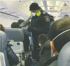  ?? Edwa rd Wang via REUTERS ?? An RCMP officer checks Canadians who had been evacuated from China on Friday due to the outbreak of novel coronaviru­s in Wuhan.