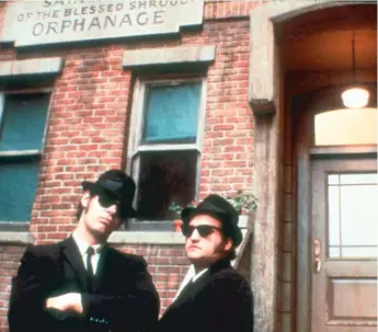  ?? | UNIVERSAL PICTURES ?? Elwood Blues ( Dan Aykroyd, left) reunites with his brother Joliet Jake ( John Belushi), fresh from a prison stay, and the musicians set about reuniting their band in “The Blues Brothers.”