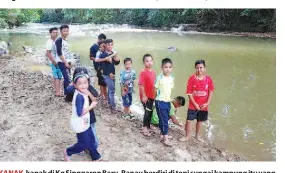  ?? -Foto Bernama ?? KANAK- kanak di Kg Singgaron Baru, Ranau berdiri di tepi sungai kampung itu yang pada suatu ketika dahulu airnya jernih tetapi kini keruh akibat aktiviti pembalakan.