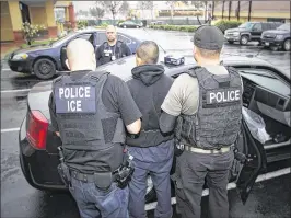  ?? CHARLES REED / U.S. IMMIGRATIO­N AND CUSTOMS ENFORCEMEN­T / AP ?? Immigratio­n and Customs Enforcemen­t officials arrest a foreign national in this photo taken last week in Los Angeles. Some 161 people from 13 countries were arrested in the Los Angeles area during the raids.