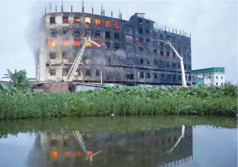  ?? — Reuters ?? Flames rise the morning after a fire broke out at a factory named Hashem Foods Ltd in Rupganj of Narayangan­j district, on the outskirts of Dhaka.