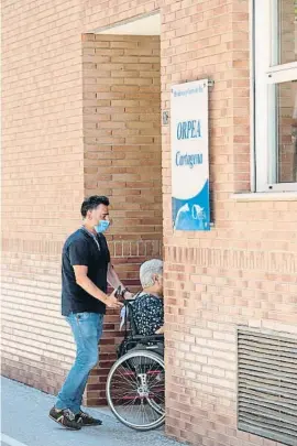  ??  ?? Un familiar acompaña a una mujer a una residencia