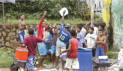  ??  ?? Mesmo com o clima de farra entre os garotos, moradores da Baixa de Quintas vão à bica desde anteontem