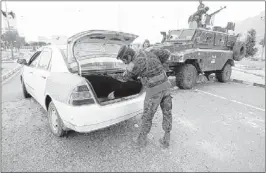  ?? HANI MOHAMMED / ASSOCIATED PRESS ?? A policeman checks a car at a checkpoint near the U. S. embassy in Sanaa, Yemen, on Tuesday. The State Department ordered non- essential personnel at the U. S. Embassy in Yemen to leave                                                                   ...