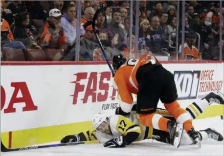  ?? MATT SLOCUM — THE ASSOCIATED PRESS ?? Pittsburgh Penguins winger Bryan Rust, left, is planted hard into the boards behind the net by Flyers defenseman Robert Hagg. Rust left the game as Hagg went to the penalty box for a questionab­le boarding call. The play was indicative of a...