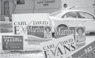  ?? Marie D. De Jesus / Houston Chronicle ?? Jonathan Davis, a supporter of District K candidate Carl Evans, answers questions Saturday from a voter at the polling place at the Leiv & Betty Platou Community Center.