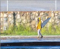  ?? PHOTO BY CHUCK BENNETT ?? An afternoon squall didn’t deter people from getting outside in San Pedro on Wednesday. The wind plays havoc with a young girl’s umbrella as she walks along Paseo Del Mar.