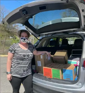  ?? Girl Scouts Western Pennsylvan­ia ?? Becky Kerr, a teacher at Chartiers Early Childhood Center, picks up boxes of Girl Scout cookies donated by GetGo Cafe and Market for distributi­on through The Education Partnershi­p.