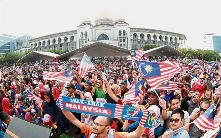  ?? — AZHAR MAHFOF and GARY CHEN/ The Star ?? Pride and joy: People came out in full force waving the Jalur Gemilang at the National Day celebratio­n in Putrajaya. (Below) Kindergart­en children and their teachers formed the largest contingent in Penang’s National Day parade - 1,030 of them - representi­ng the Penang National Unity and Integrity Department.