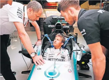  ?? FOTO: PA ?? Was können wir tun? Nico Rosberg tauscht sich mit einem Ingenieur aus, während ein Mechaniker am Auto arbeitet.