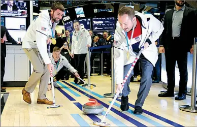  ?? AP/RICHARD DREW ?? U.S. Olympic gold medalists in curling John Landsteine­r (from left), Matt Hamilton, Joe Polo and Tyler George demonstrat­e their skill Friday on the floor of the New York Stock Exchange before ringing the opening bell. The Standard & Poor’s 500 index...