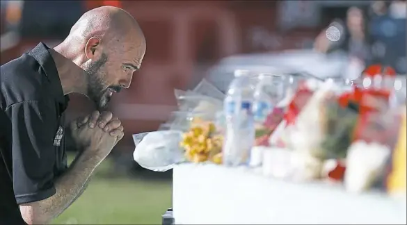  ?? Brynn Anderson/Associated Press ?? Kevin Siegelbaum, a special education teacher at Marjory Stoneman Douglas High School, leans in to pray Thursday in Parkland, Fla., during a community vigil for the victims of the shooting at the school.