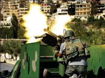  ??  ?? Battle ground: A Syrian soldier fires during clashes with rebels in Maaloula