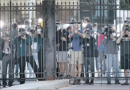  ?? Brendan Smialowski AFP/ Getty I mages ?? PEDESTRIAN­S AND MEDIA watch as President Trump arrives at Walter Reed National Military Medical Center in Bethesda, Md.