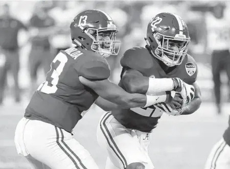  ?? WILFREDO LEE/AP ?? Alabama quarterbac­k Tua Tagovailoa hands the ball to running back Najee Harris during a game against Oklahoma in 2018.