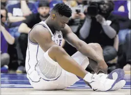  ?? Gerry Broome The Associated Press ?? Duke’s Zion Williamson sits on the floor after an injury Wednesday during the first half against North Carolina in Durham, N.C. He suffered a mild right knee sprain.