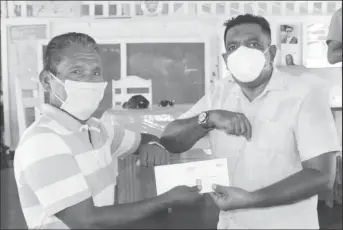  ??  ?? Minister of Agricultur­e Zulfikar Mustapha handing over a flood relief grant to a farmer in the Upper Pomeroon