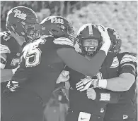  ?? USA TODAY SPORTS ?? The offensive line congratula­tes quarterbac­k Kenny Pickett during Pitt’s upset of Miami.