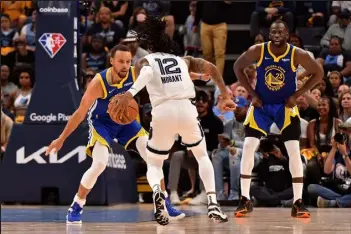  ?? JUSTIN FORD / Getty Images ?? Memphis Grizzlies guard Ja Morant handles the ball against Stephen Curry and Draymond Green, right, of the Golden State Warriors during Sunday’s playoff game at Fedexforum in Memphis, Tenn.