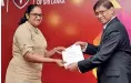  ??  ?? CA Sri Lanka CEO Dulani Fernando awarding a diploma certificat­e to a student who successful­ly completed the DISCCA programme