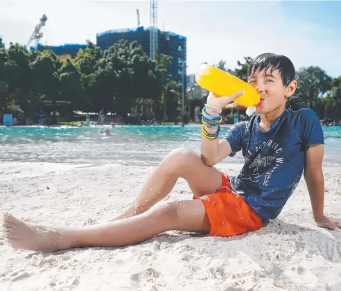  ?? Picture: RENDAN RADKE ?? REFRESHING DRINK: Jeremy Bherer, 8, quenches his thirst while enjoying the day out at the Cairns Lagoon.